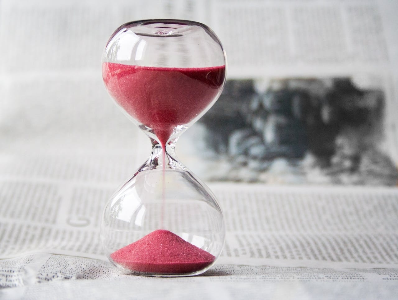 The hourglass sits on a newspaper, pointing out that time never waits and a toxic relationship is indeed a waste of time.